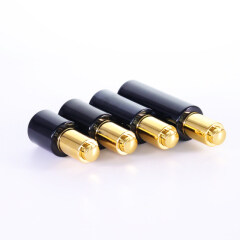 Opaque black glass bottle with golden dropper for essential oil