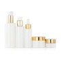 Opal white glass bottle and jar with golden aluminum top for skin care