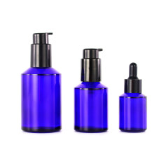 Empty cobalt blue glass cosmetic lotion pump bottles