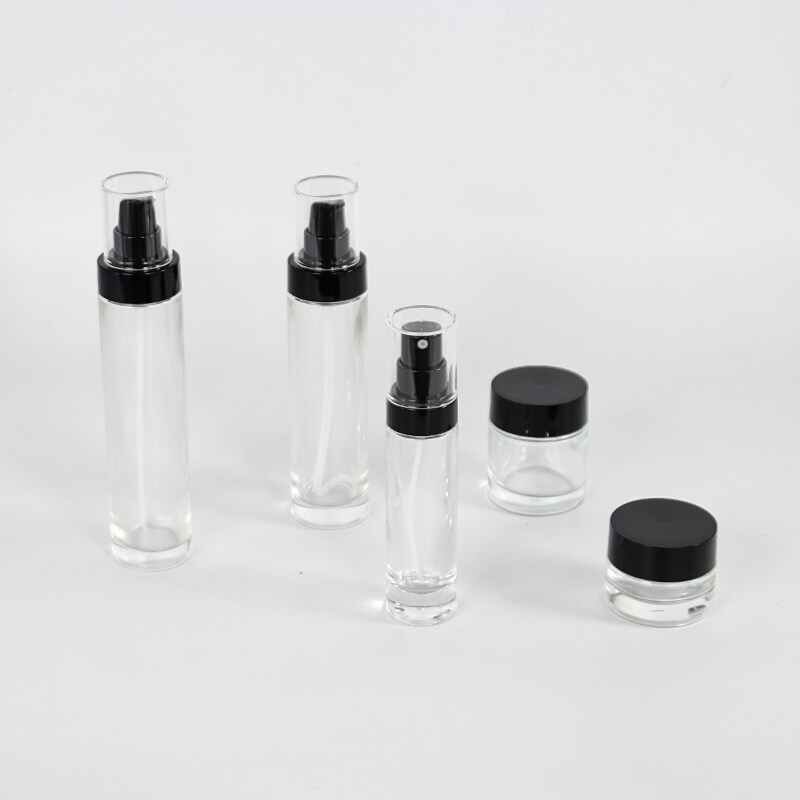 Wholesale cosmetic packaging set environmentally friendly empty clear frosted glass bottle and jar sets with black lid